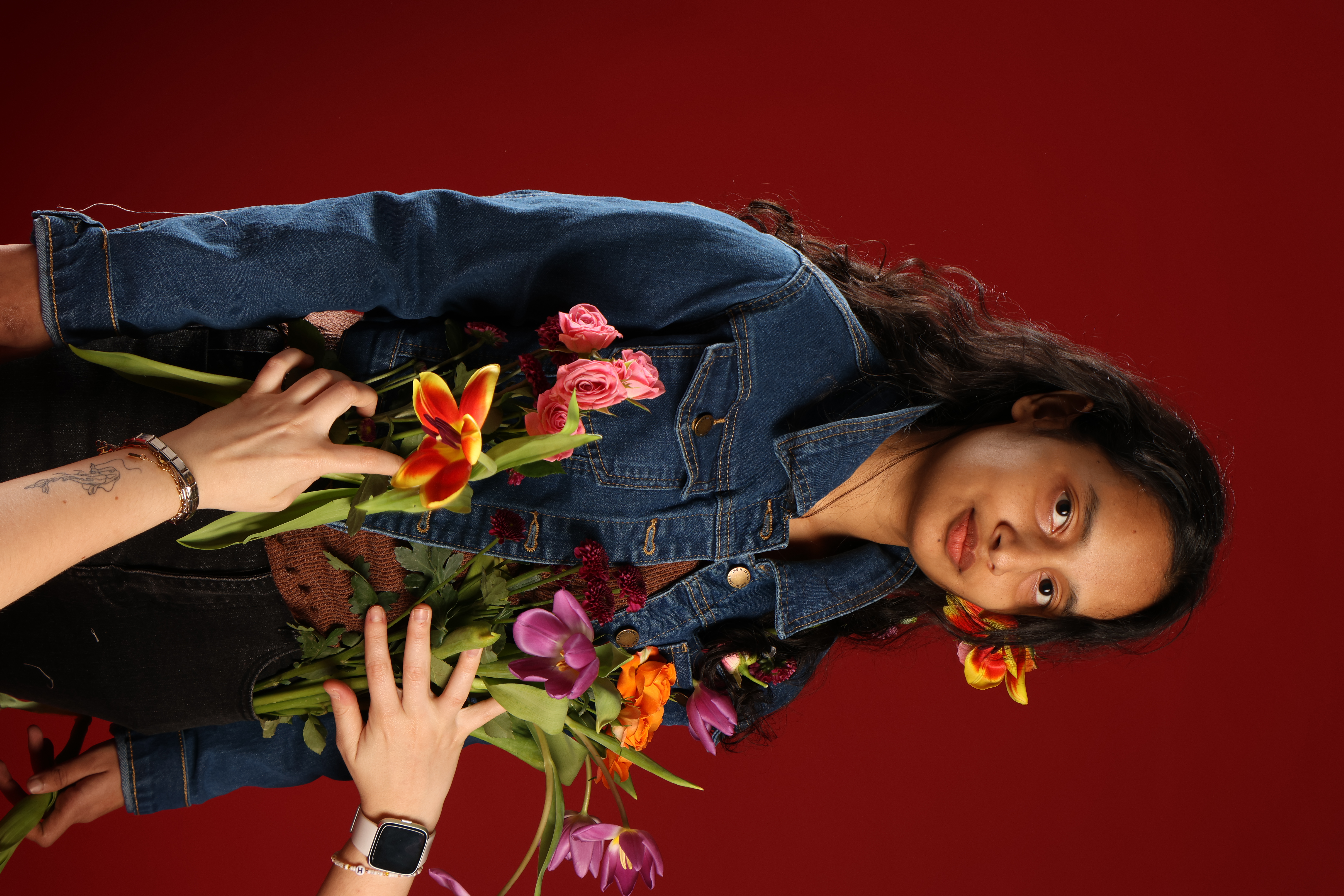 Surface and embroidery work — hands holding flowers, detail